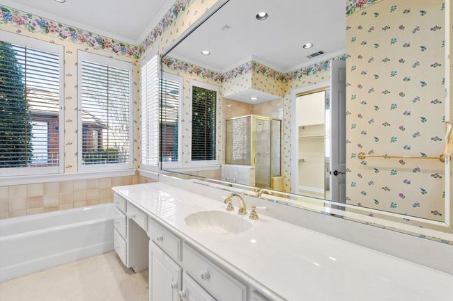 Tons of vanity space in this secondary bedroom with a separate tub and shower with the BIGGEST walk in closet! | Image 33