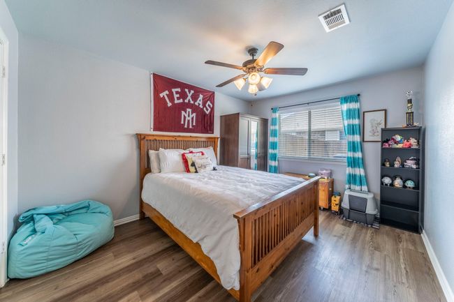 Bedroom featuring wood finished floors, baseboards, and ceiling fan | Image 19