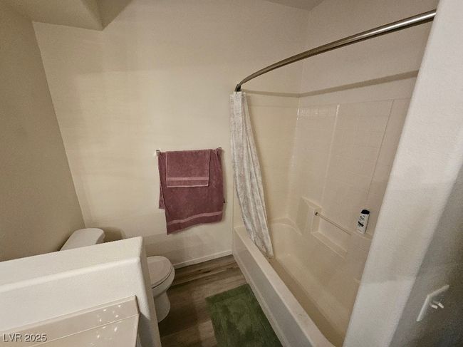 Full bathroom with shower / bath combo with shower curtain, wood finished floors, and toilet | Image 22