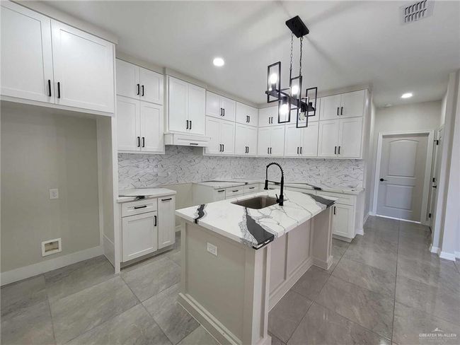 Kitchen featuring white cabinets, sink, and pendant lighting | Image 10