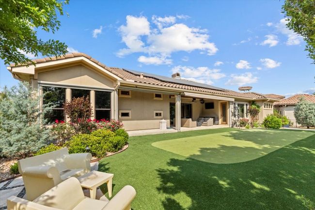 Back of house with solar panels, a ceiling fan, a patio, stucco siding, and an outdoor living space | Image 30