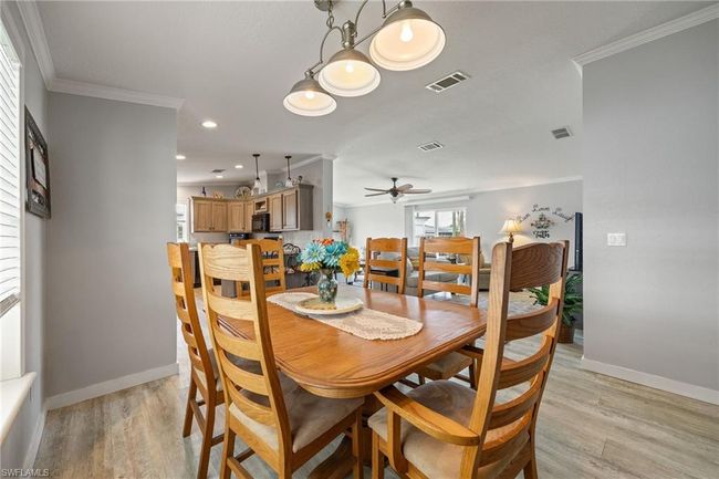 Dining space with crown molding, visible vents, and baseboards | Image 13