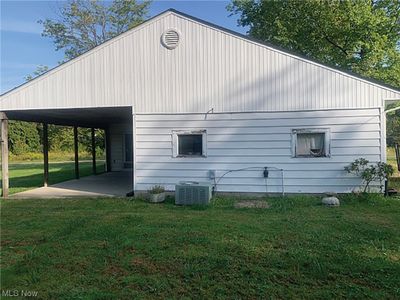 View of home's exterior featuring central air condition unit, a yard, and a carport | Image 3