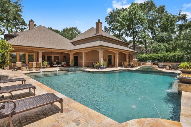 The outdoor kitchen boasts a gas grill, komodo, electric smoker, fridge, and ice maker. Both the outdoor fridge and ice maker are new in 2024! | Image 46