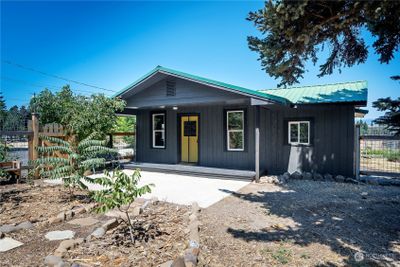 Enjoy the convenience of a covered porch with easy access to the fenced yard. | Image 1