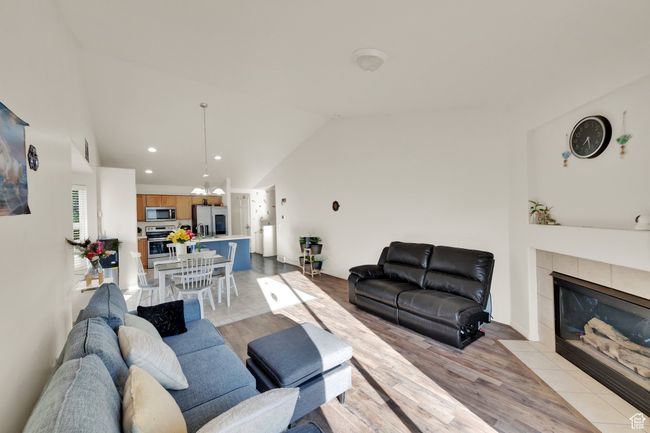 Living room featuring lofted ceiling, light wood-style floors, a tile fireplace, and recessed lighting | Image 10