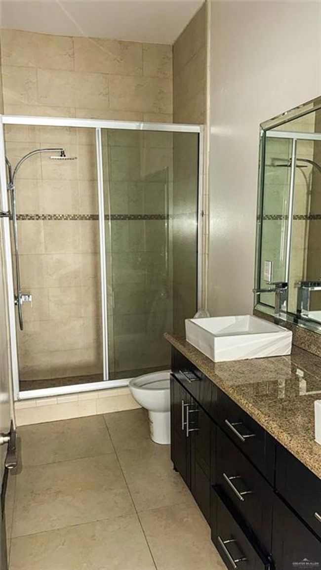 The primary bathroom is complete with double vanities and a walk in shower. | Image 8