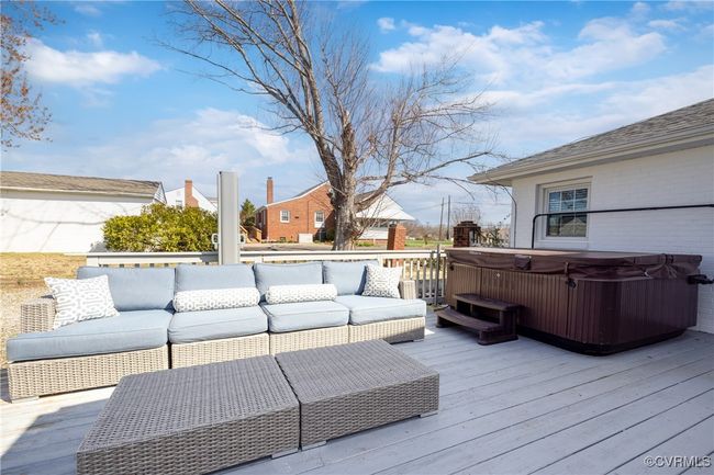 Wooden terrace featuring a hot tub and an outdoor hangout area | Image 30