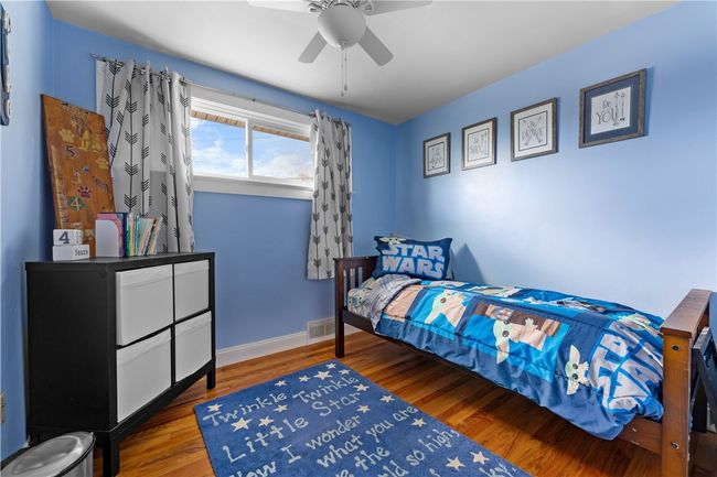 Bedroom three also features lovely hardwood floors and ceiling fan. | Image 14