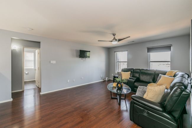 Living room featuring ceiling fan and dark wood-style floors | Image 16