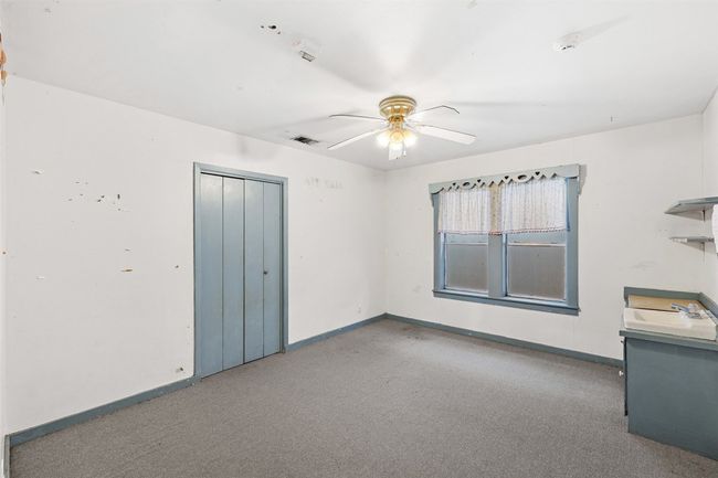 Empty room with visible vents, carpet floors, baseboards, and ceiling fan | Image 19