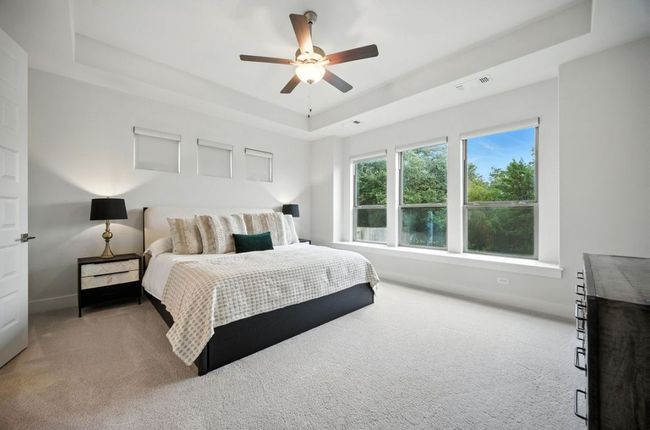 Carpeted bedroom with a tray ceiling and ceiling fan | Image 20