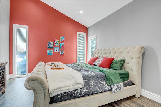 Bedroom featuring baseboards, high vaulted ceiling, wood finished floors, and recessed lighting | Image 23