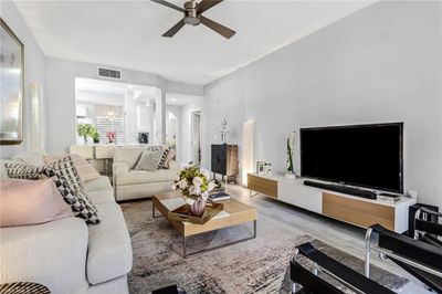 Living room featuring ceiling fan with notable chandelier and hardwood / wood-style floors | Image 3