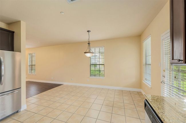 Unfurnished dining area with light tile patterned floors and baseboards | Image 11