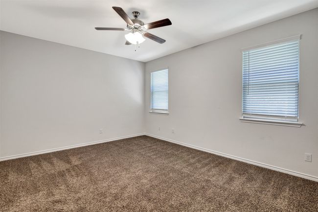 Spare room featuring dark colored carpet and ceiling fan | Image 14