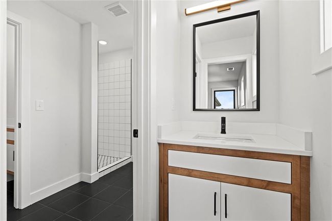 Bathroom with vanity, a shower stall, and tile patterned flooring | Image 29