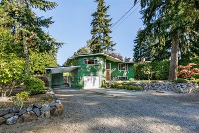 Welcome to 5384 NE 197th St in Kenmore! This 1961 mid-century split-level is positioned on a level 7, 600 sq ft lot, with a newer green metal roof, 1 car garage, and 2-car tandem carport or boat/ RV parking! | Image 1