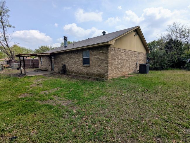 View of property exterior with brick siding, a patio, and central air condition unit | Image 21
