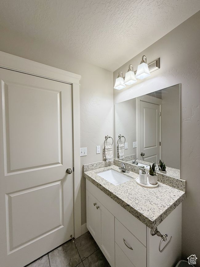 Bathroom featuring vanity, tile patterned floors, and a textured ceiling | Image 9