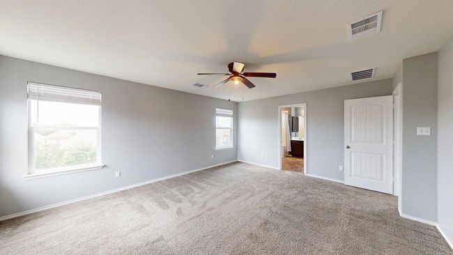 Carpeted empty room featuring visible vents, a ceiling fan, and baseboards | Image 25