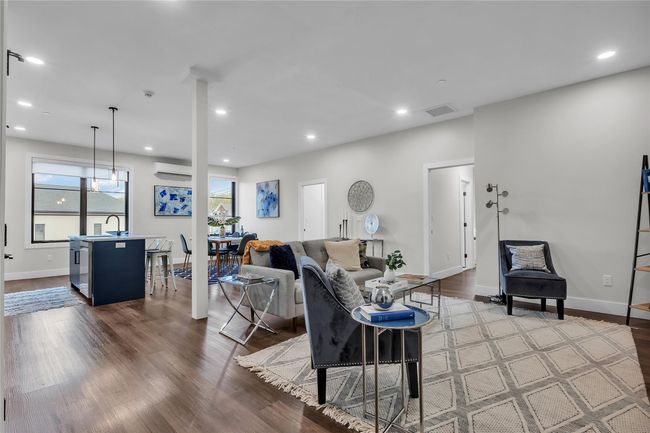 Living room featuring wood finished floors, recessed lighting, baseboards, and an AC wall unit | Image 4