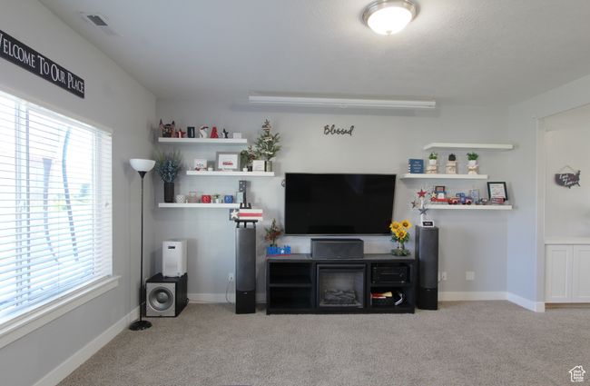 Living area featuring carpet floors and healthy amount of natural light | Image 5