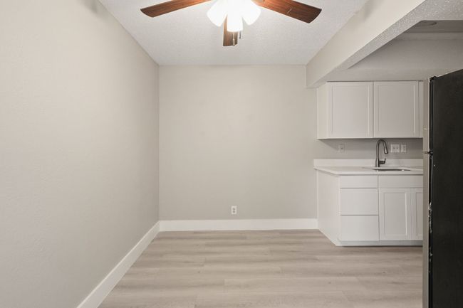 Unfurnished dining area featuring a ceiling fan, light wood-style flooring, and a textured ceiling | Image 4