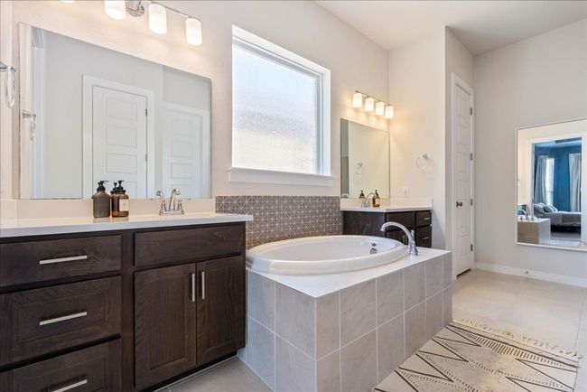Bathroom featuring a sink, a bath, two vanities, and tile patterned flooring | Image 21