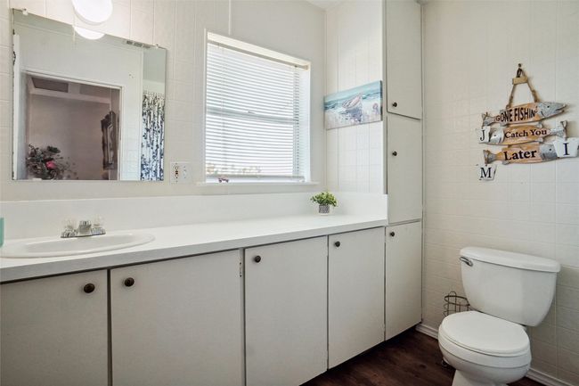 Full bath featuring vanity, tile walls, toilet, and wood finished floors | Image 17