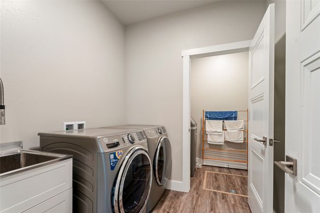 Laundry area with washing machine and clothes dryer, wood finished floors, and baseboards | Image 21