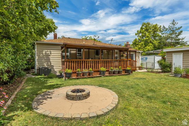 Back of property with a chimney, a lawn, an outdoor fire pit, and a deck | Image 17