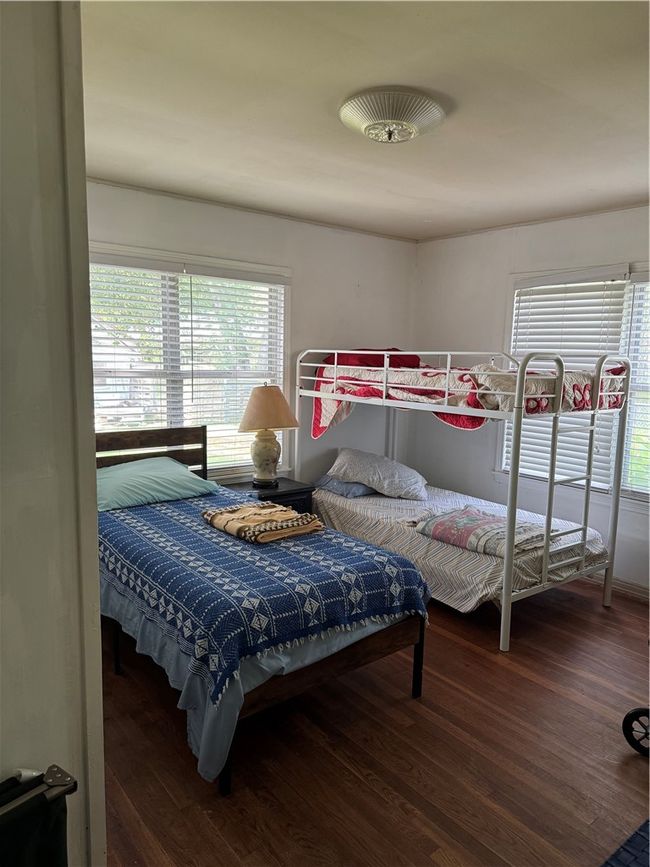 Bedroom featuring wood finished floors and multiple windows | Image 13