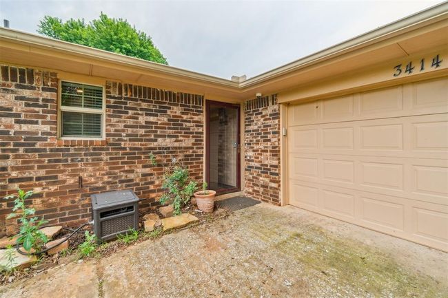 View of exterior entry featuring brick siding, driveway, and a garage | Image 5