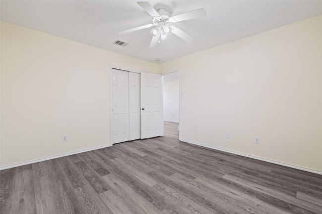 Unfurnished bedroom with wood finished floors, baseboards, a closet, and ceiling fan | Image 27