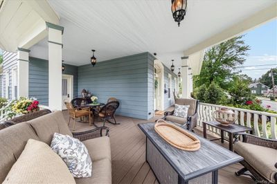 Wrap-around front porch is the perfect place for watching village parades and events | Image 3