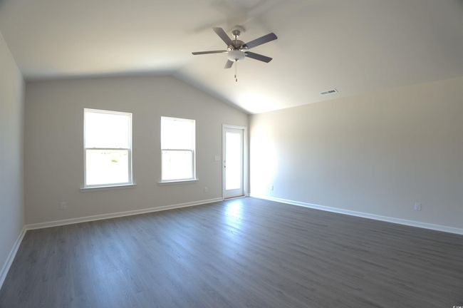Spare room featuring a ceiling fan, dark wood-style flooring, and vaulted ceiling | Image 10