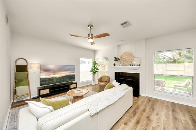 Step into the family room and be captivated by its bright, airy design. Large windows let in an abundance of natural light, while the modern touches create a warm, welcoming atmosphere that makes this space truly shine. | Image 12