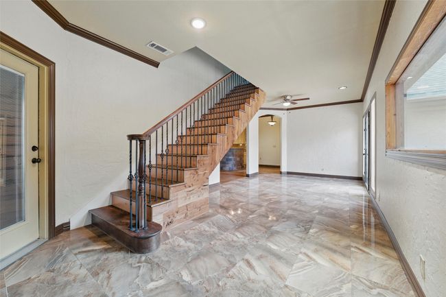 Staircase with arched walkways, ornamental molding, a ceiling fan, marble tiled flooring, and baseboards | Image 19