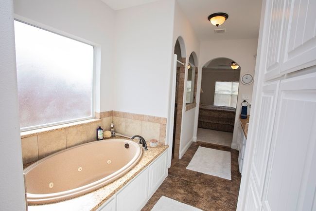 Full bathroom with double vanity, tiled shower, a bathtub, and tile patterned flooring | Image 11
