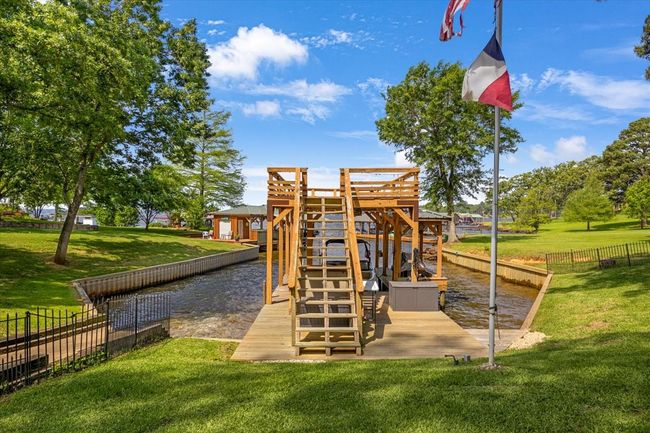 View of playground featuring fence, a yard, and a water view | Image 34
