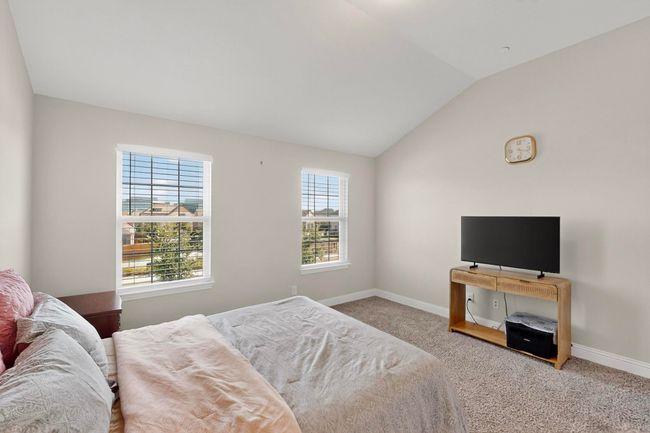Carpeted bedroom with baseboards and lofted ceiling | Image 15