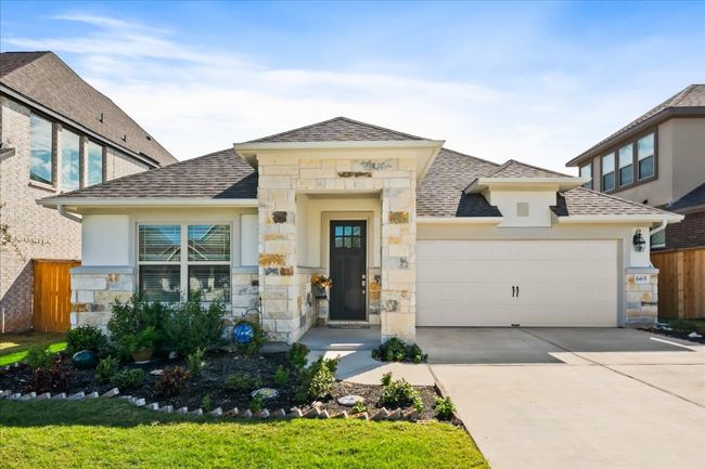 View of front of house featuring stone siding, concrete driveway, an attached garage, and a shingled roof | Image 36
