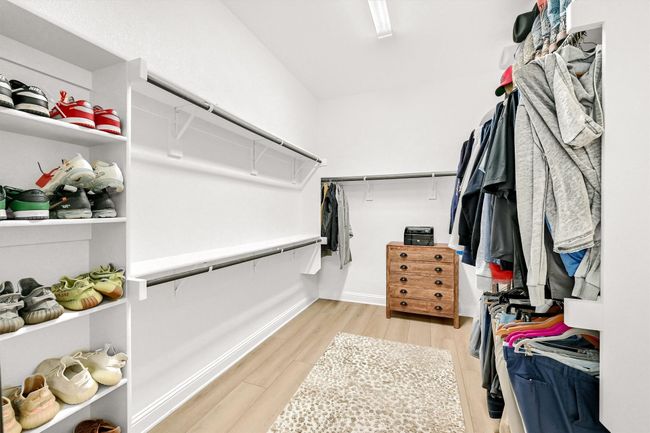 Spacious closet with light wood-style flooring | Image 21