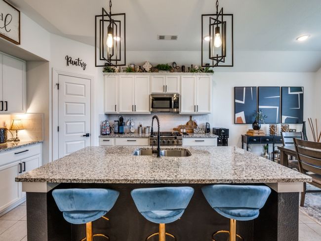 Kitchen featuring backsplash, visible vents, light tile patterned floors, stainless steel microwave, and a sink | Image 14