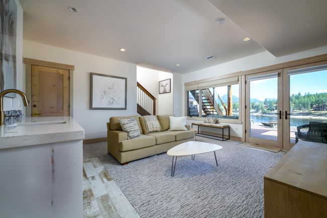 Lower level great room, with a bank of glass doors leading to the outdoor patio with a hot tub | Image 23