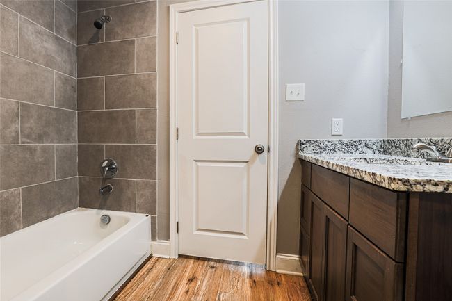 Full bathroom with vanity, wood finished floors, and shower / washtub combination | Image 4