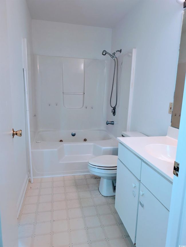 Full bath featuring tile patterned floors, vanity, and shower / tub combination | Image 7