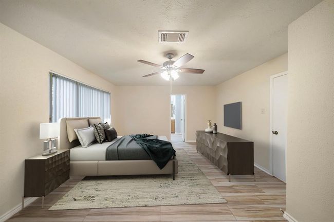 Expansive primary suite on the first floor offers room for a king bed and additional furnishings, with large windows delivering natural light and a tranquil atmosphere. This photo has been virtually staged. | Image 19