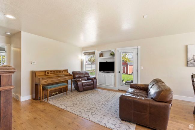 Living area with baseboards, light wood-style floors, and a healthy amount of sunlight | Image 15